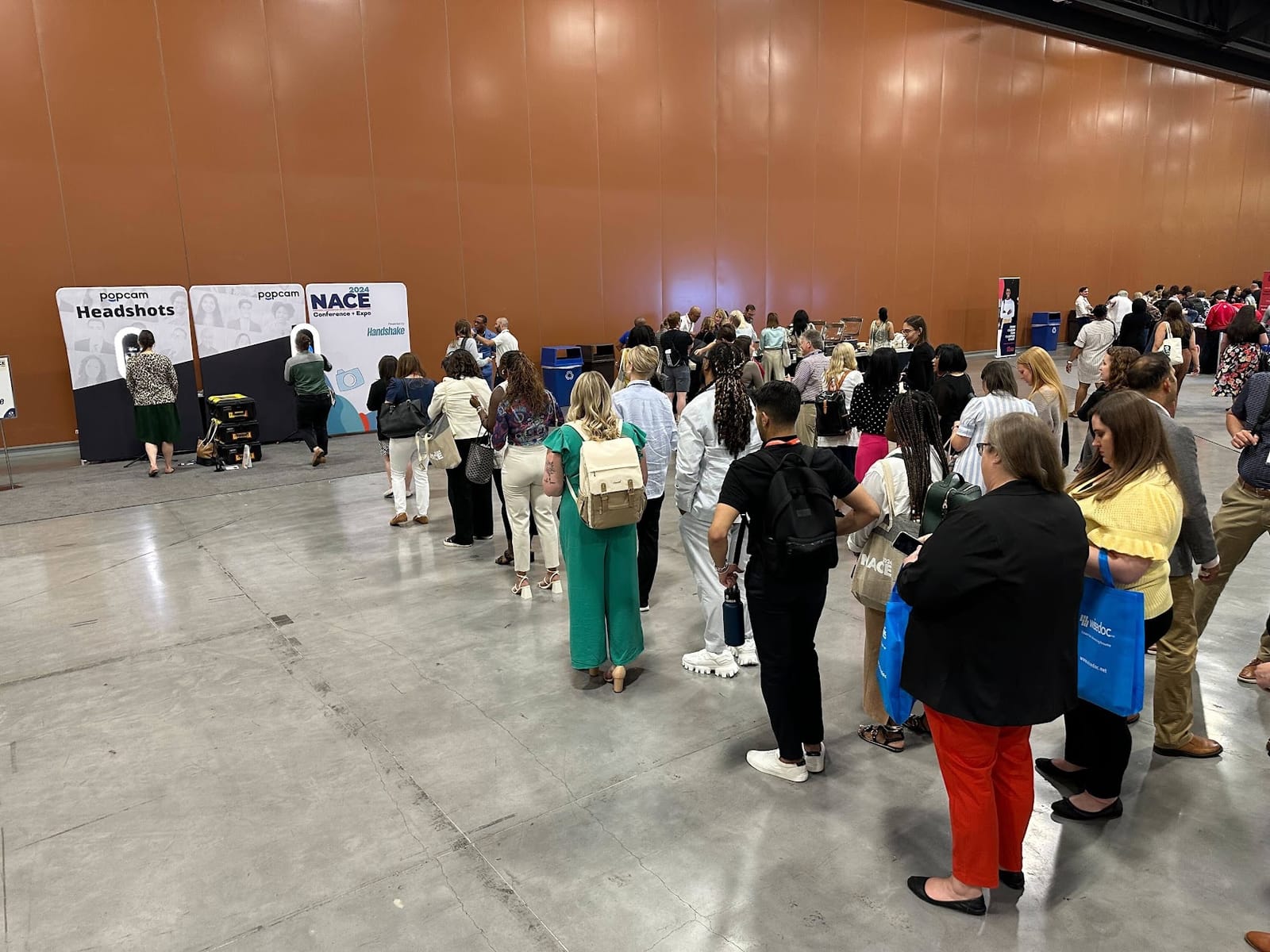 A long line of attendees waiting for Popcam headshots at the NACE 2024 conference